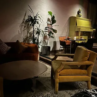 a living room with a couch, chair, coffee table, and piano