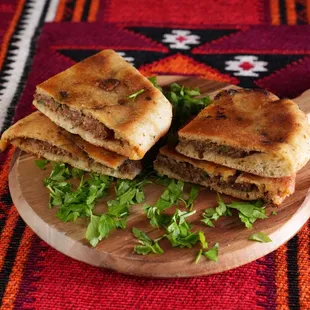 Ha-wow-shi our signature dish 
 Well seasoned ground beef in a special crusty pita bread, served with hummus sauce and lettuce