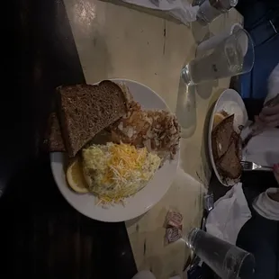 a plate of eggs, toast, and bread