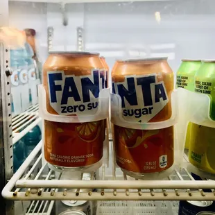 two cans of fanta in a refrigerator