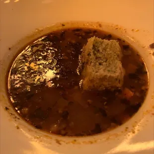 a bowl of soup with a piece of bread