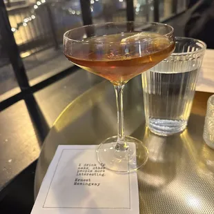 a glass of water and a drink on a table