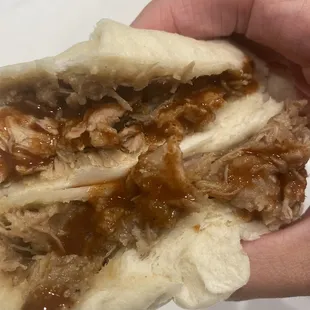 Siopao cut in half and topped with hot sauce