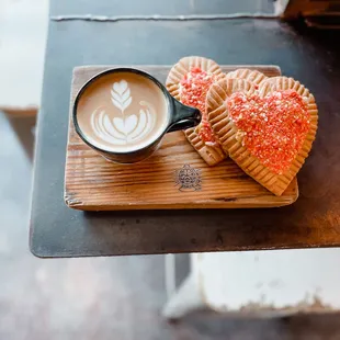 two heart shaped pastries and a cup of coffee