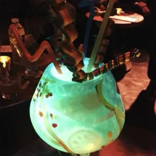 a glass vase with a lit candle in it