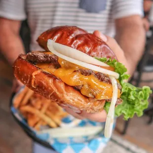 a person holding a hamburger and french fries