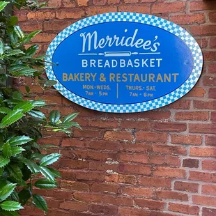 a blue sign on a brick wall