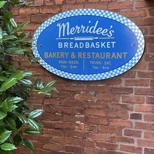 a blue sign on a brick wall