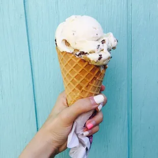 a hand holding an ice cream cone
