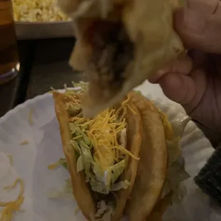 a hand holding a taco