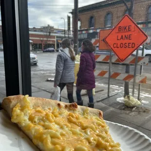 a slice of pizza on a paper plate