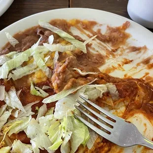 a plate of enchilada with a fork and knife
