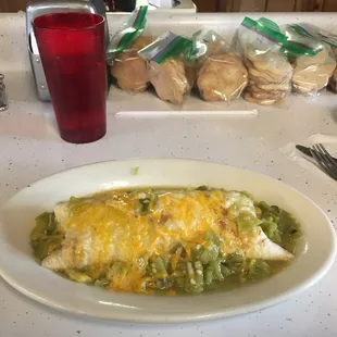 Breakfast burrito smothered in green Chile.