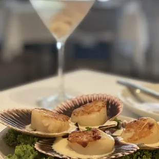 a plate of scallops and a martini