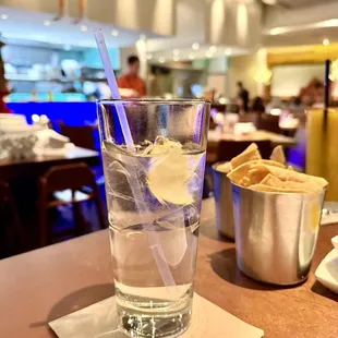 a glass of water with ice and chips