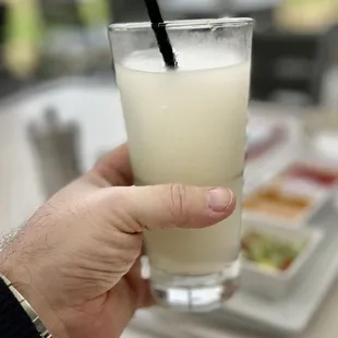 a hand holding a glass of milk