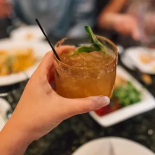 a person holding a drink at a restaurant