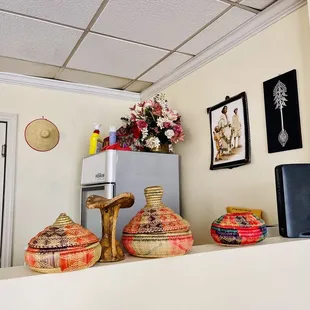 a kitchen with a refrigerator, microwave, and baskets