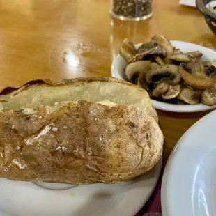 Baked potato and grilled mushrooms sides.