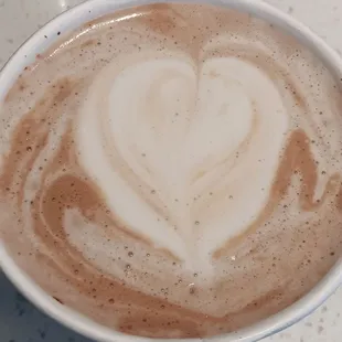 a cup of coffee with a heart drawn in the foam