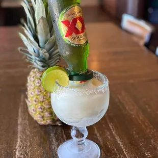 a pineapple and a bottle of beer on a table