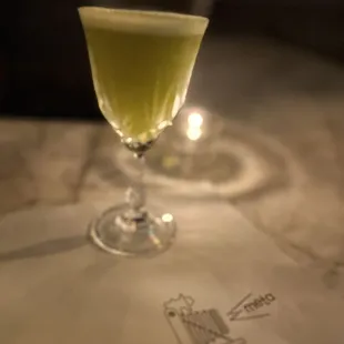 a glass of green liquid on a table