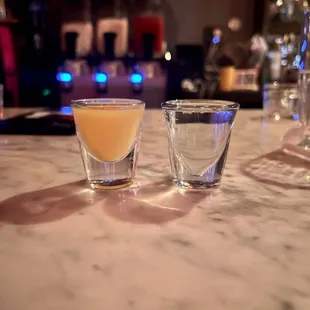two shot glasses on a marble table