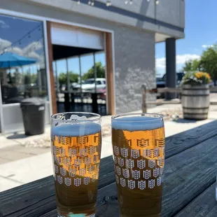 two glasses of beer on a picnic table