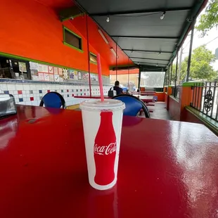 a coca cola cup on a red table