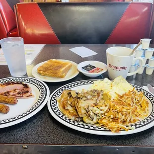 Meat lovers pork chop covered with onions and mushrooms and eggs , side of ham and sausage links and coffee and water