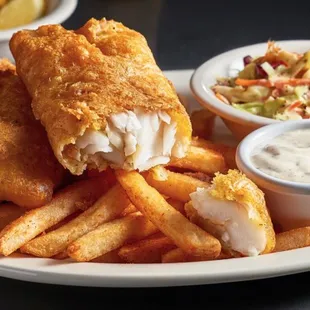 a plate of fish and chips with a side of coleslaw