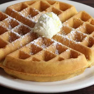 a plate of waffles with a scoop of butter