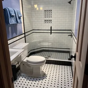 a bathroom with black and white tile
