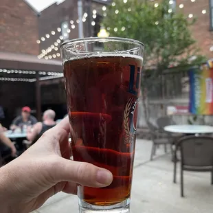 a person holding a glass of beer