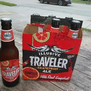 a bottle of traveler ale next to a bag of beer