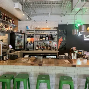 a view of a bar with green stools