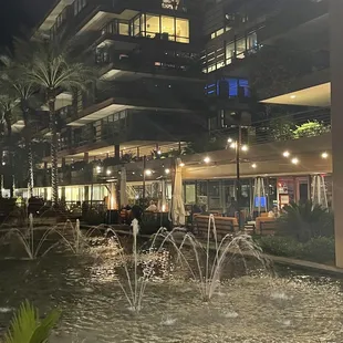 a fountain in the middle of a city at night