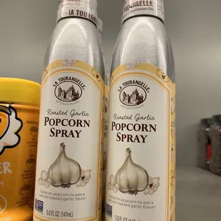 two bottles of popcorn spray on a shelf