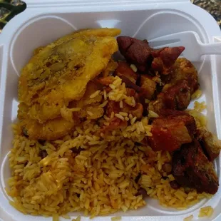 Yellow rice and pigeon peas, fried pork chunks, and fried green plantains