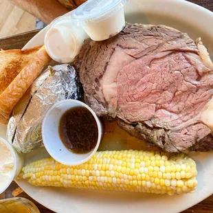 a plate of steak, corn and bread