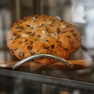 a chocolate chip cookie in a glass case