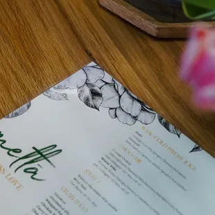 a menu and a vase of tulips