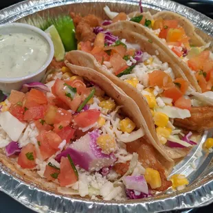 Beer Battered Fish Tacos (3). Corn tortillas, white fish, purple &amp; green cabbage, corn, queso fresco, pico, creamy avocado sauce. $11.50.
