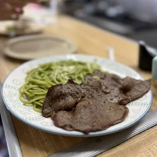 a plate of meat and green beans