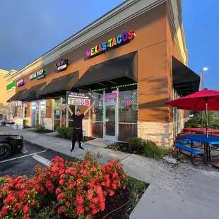 a woman standing in front of a taco shop