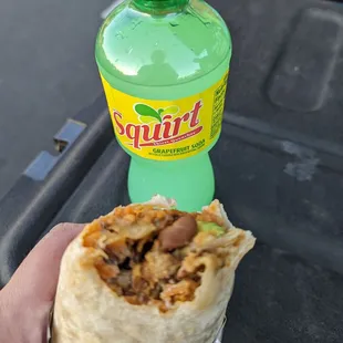 a hand holding a burrito