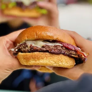 a person holding a hamburger