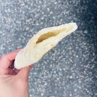 a hand holding a piece of bread