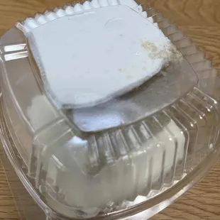 Tres leches cake - it&apos;s two layers, so thick it as busting out of the container. See the smooshed icing?