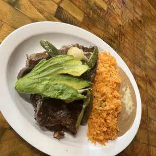 Our plate of carne asada accompanied by beans and rice as well as avocado, a fried jalapeño and Mexican spring onion and tortillas